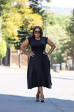 Black sleeveless A-line midi dress with flared skirt