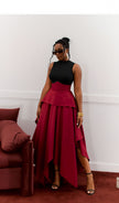 Maroon two-piece set with sleeveless high-neck top and high-waist asymmetric hem skirt