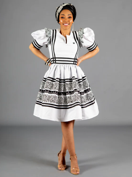 White puff-sleeve traditional dress with black-and-white striped trim and tiered skirt