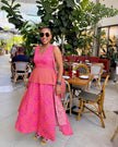 Traditional maxi dress with vibrant pink and orange print, sleeveless with flared skirt