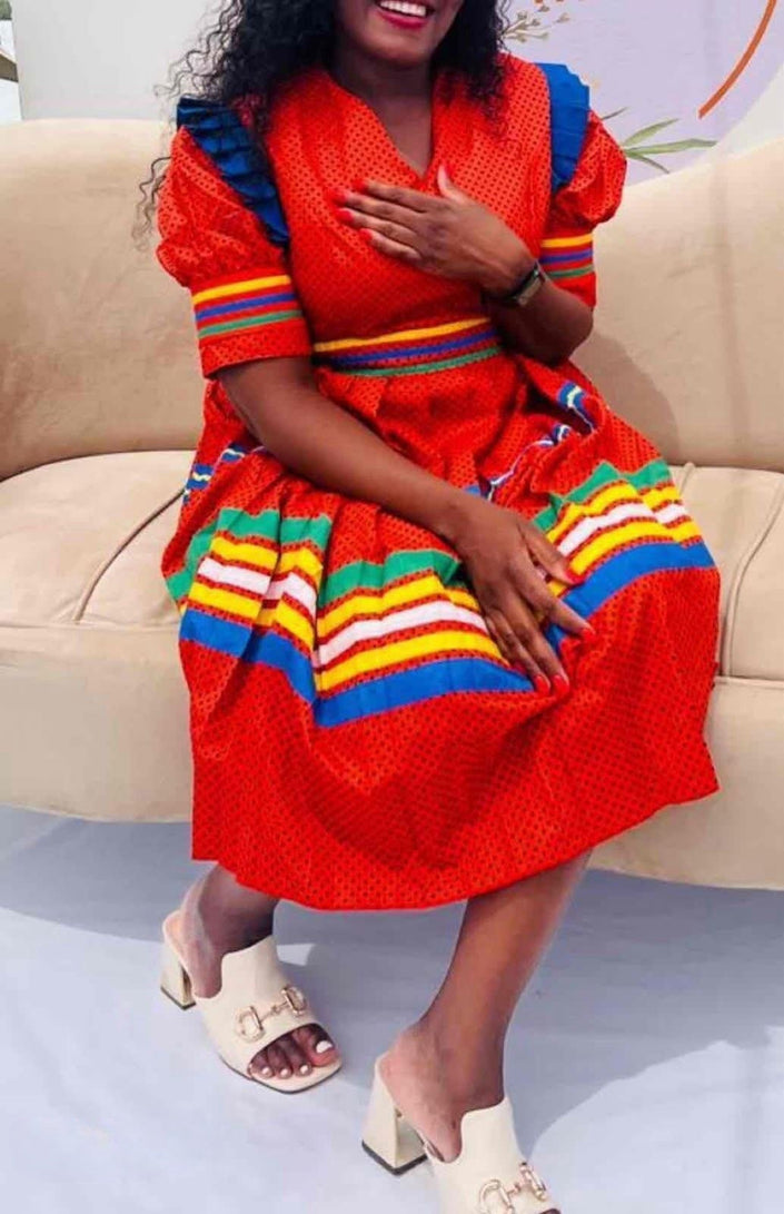Red belted midi dress with puff sleeves and rainbow striped skirt