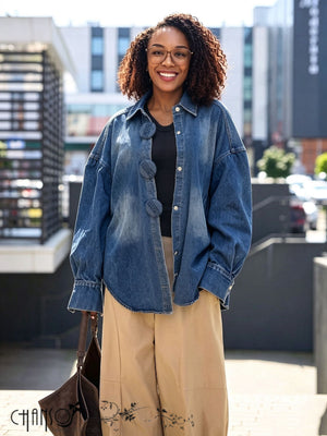 Oversized blue denim shirt jacket with dropped shoulders, long sleeves, and round buttons