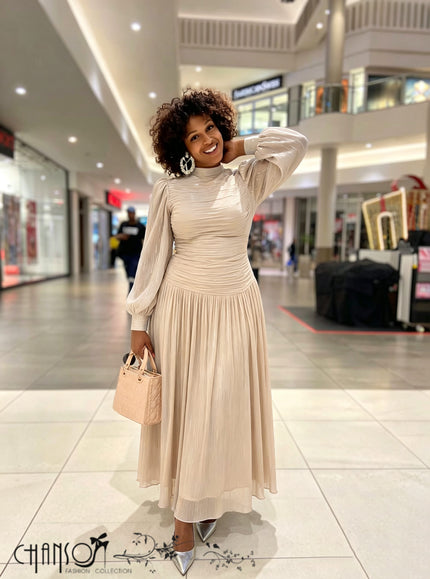 Nude ruched high-neck maxi dress with sheer long sleeves and flowing pleated skirt
