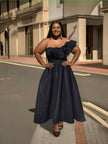 One-shoulder ruffle evening dress with dark textured skirt and fitted waist.