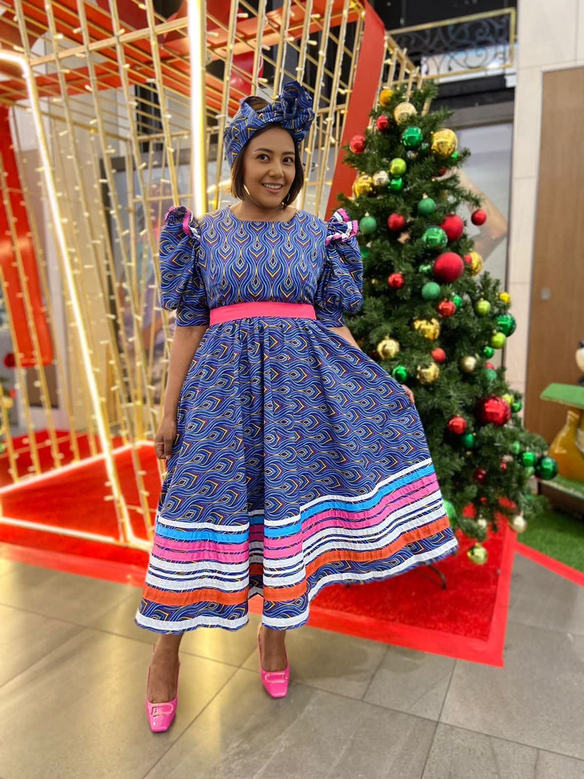 Plus size A-line dress with blue patterned puff sleeves, pink waistband, striped skirt