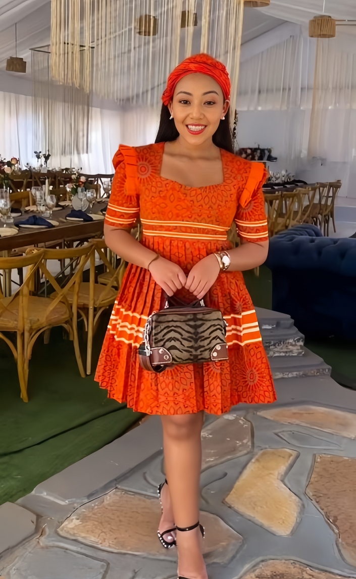 Orange traditional dress with puff sleeves, square neckline and embroidered border