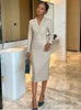 Light beige double-breasted midi dress with long sleeves, V-neck, and fitted waist