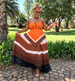 Orange black white striped strapless traditional South African maxi dress modeled outdoors