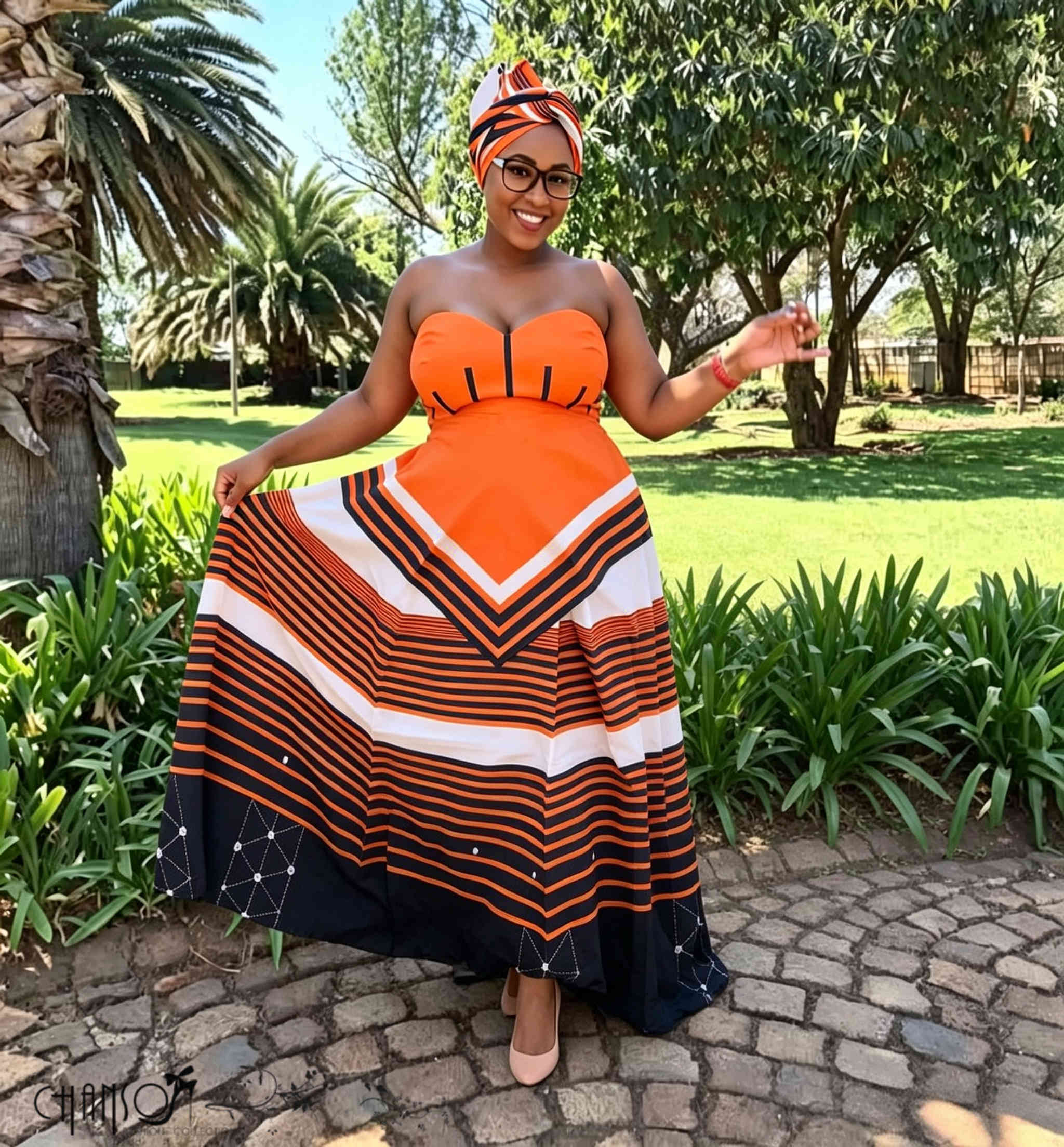 Orange black white striped strapless traditional South African maxi dress modeled outdoors