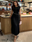 Black sleeveless pleated knit dress with button front and belt tie