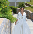 White floral maxi dress with puff sleeves and A-line skirt, V-neck.