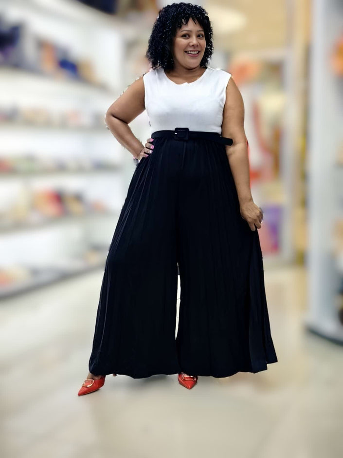 Belted pleated wide-leg jumpsuit with sleeveless white top, dark waist and flowing legs