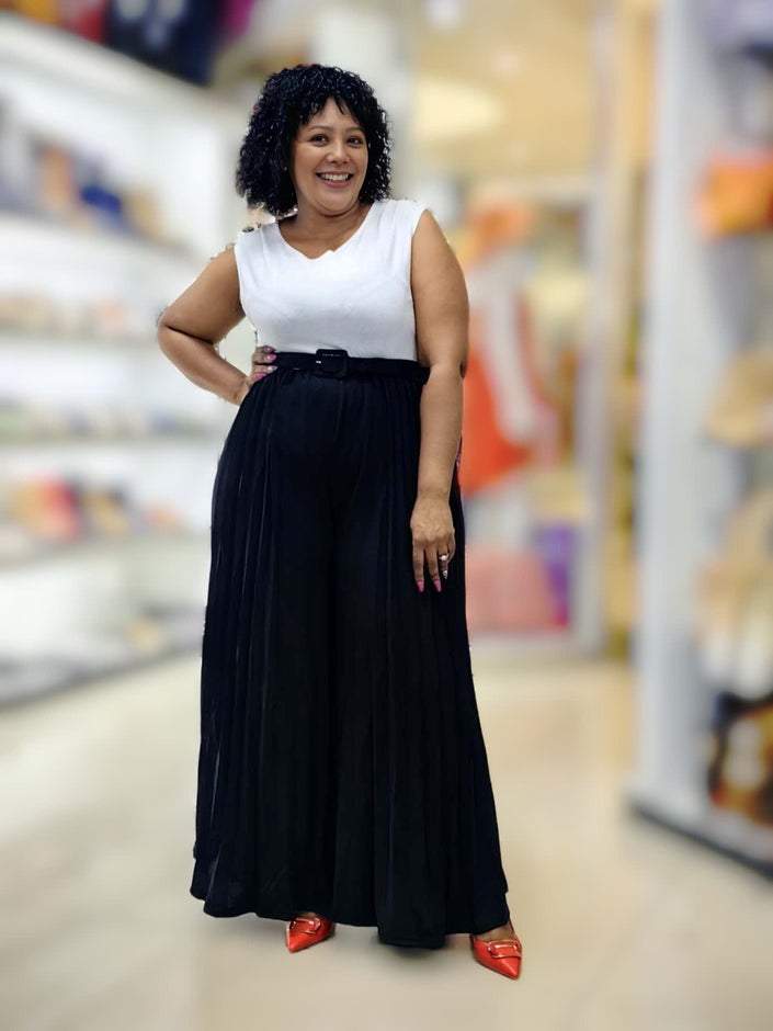 Pleated wide-leg jumpsuit with sleeveless white top and black belted pleated skirt