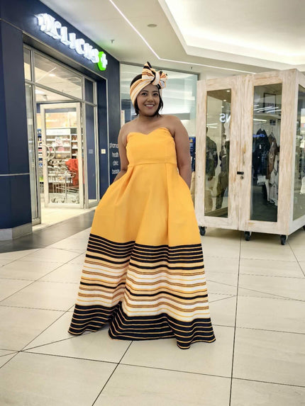 Strapless maxi dress with flared skirt in mustard yellow and dark striped hem
