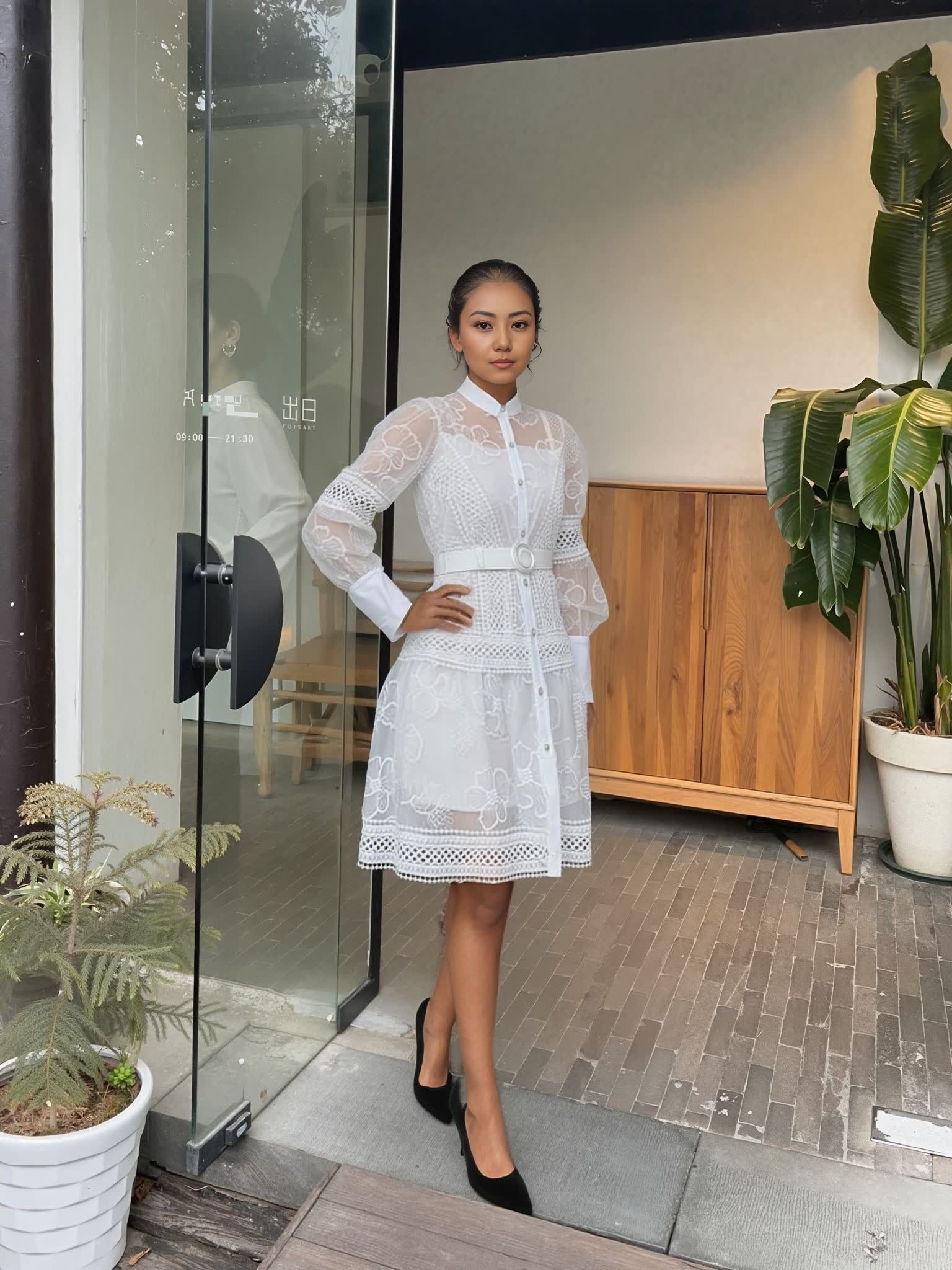 White layered lace mini dress with long puff sleeves, button front, and fitted belt