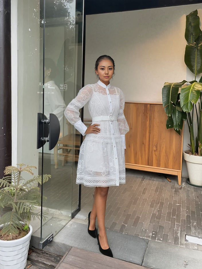 White lace mini dress with belted waist, high neckline, long sleeves with lace detailing.