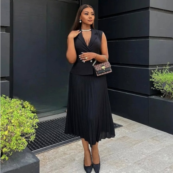 Black belted sleeveless blazer with pleated midi skirt, chic twin set
