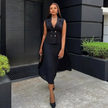 Black belted sleeveless blazer and pleated midi skirt set, buttoned front