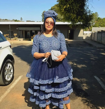 Blue African print layered dress with ruffled tiers, long sleeves, crew neck.