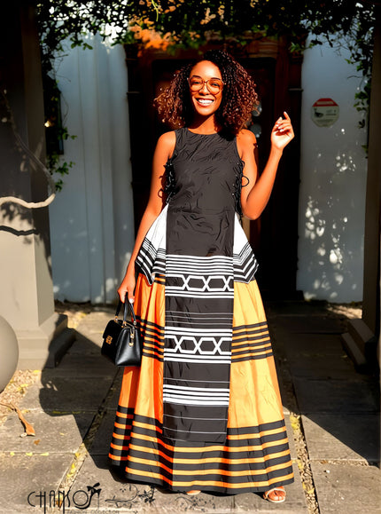 Sleeveless maxi dress with geometric striped pattern in black, orange, cream, and white