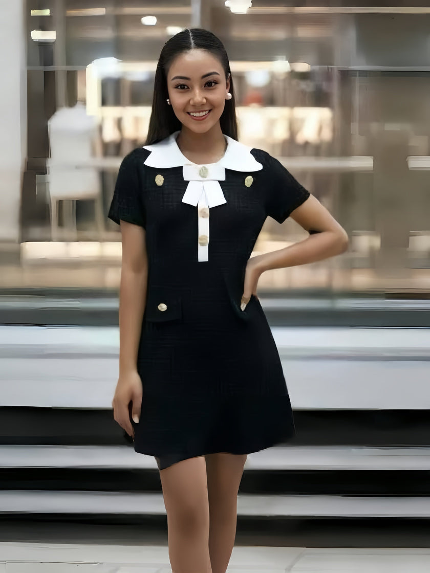 Black vintage-style dress with white collar and gold buttons