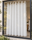 White eyelet curtains with abstract speckled pattern, hung from bronze metal grommets