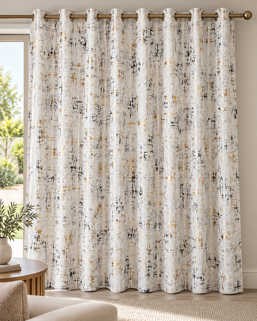 Cream white eyelet curtains with abstract speckled pattern, hanging from top bronze rings