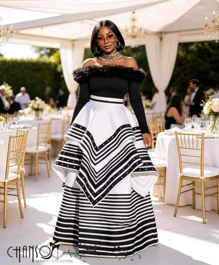 Off-shoulder black maxi gown with feather-trim neckline, long sleeves, striped tiered skirt