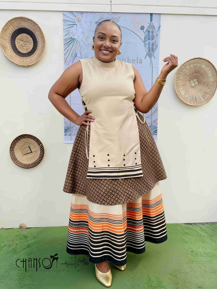 Layered sleeveless maxi dress with cream bodice and striped black orange skirt