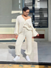 Cream knit twin set with button-front cardigan and matching knit pants.