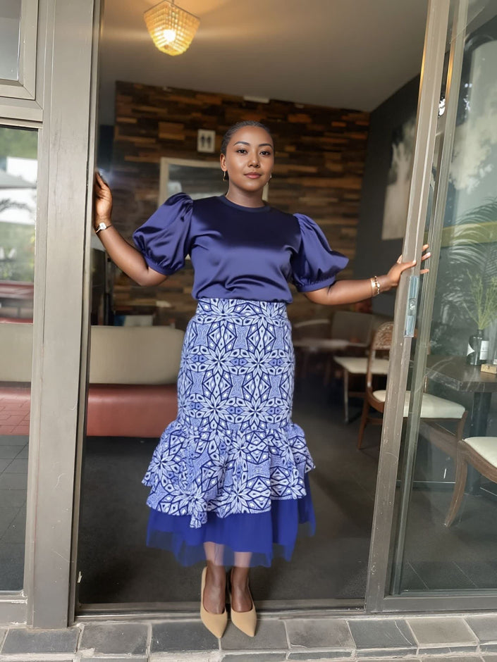 Navy puff-sleeve blouse with layered blue patterned skirt and tulle hem