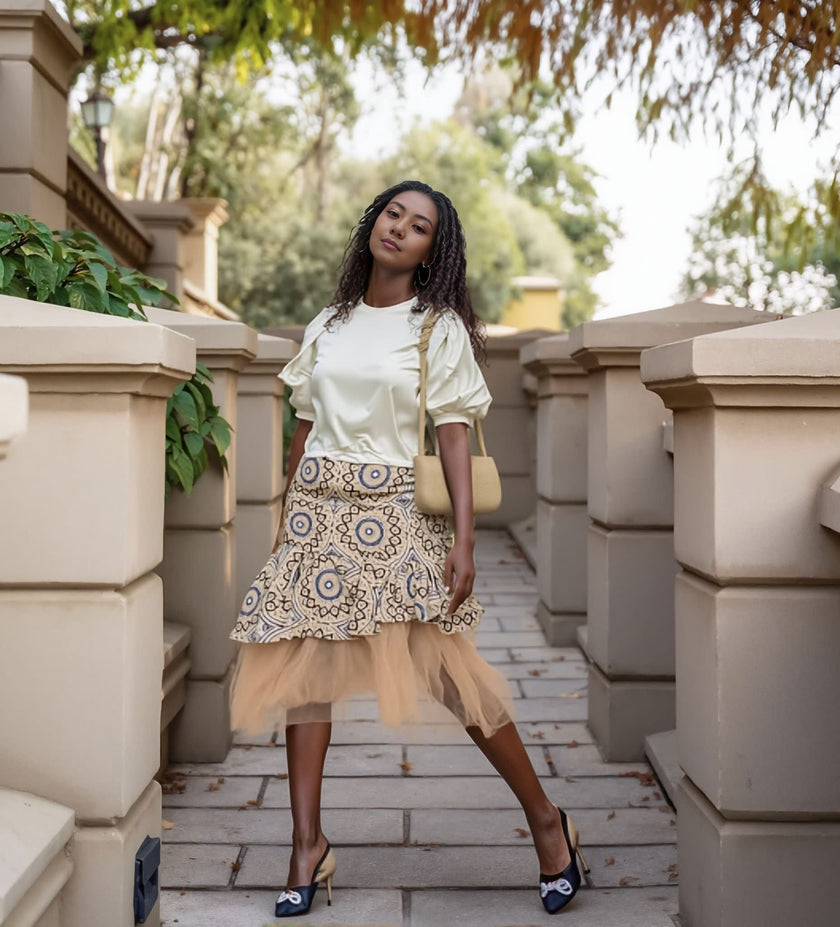 Cream puff-sleeve blouse with layered patterned skirt and beige tulle hem