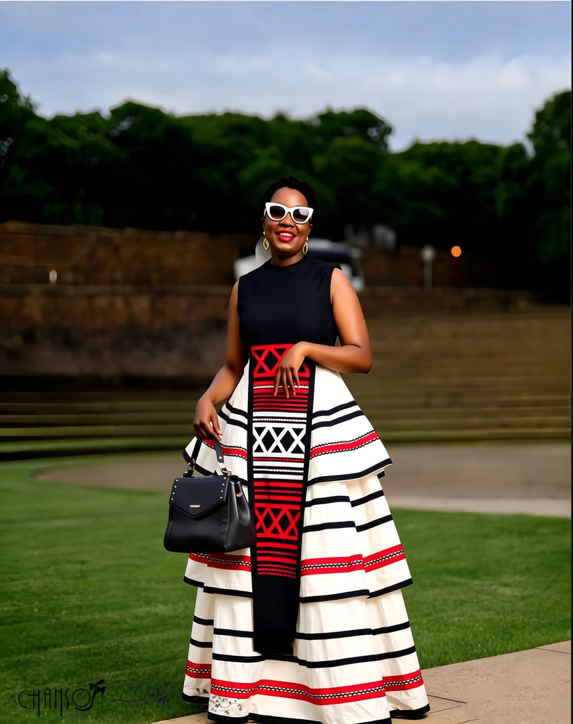 Sleeveless high-neck maxi dress with geometric red, black, and white striped tiered skirt