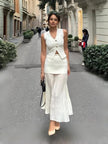 White sleeveless vest with gold buttons and pleated midi skirt, matching set