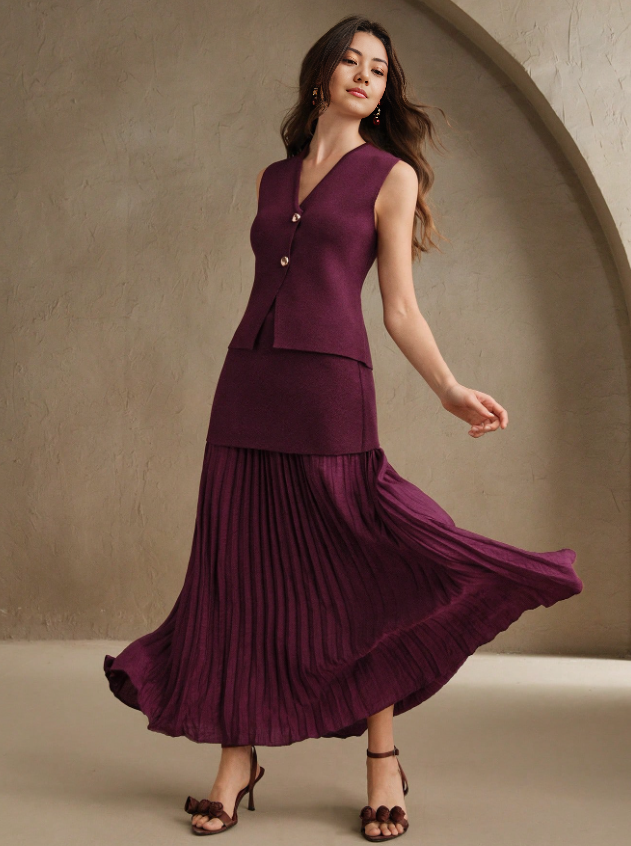 Maroon sleeveless vest with gold buttons and pleated midi skirt, flowing hem