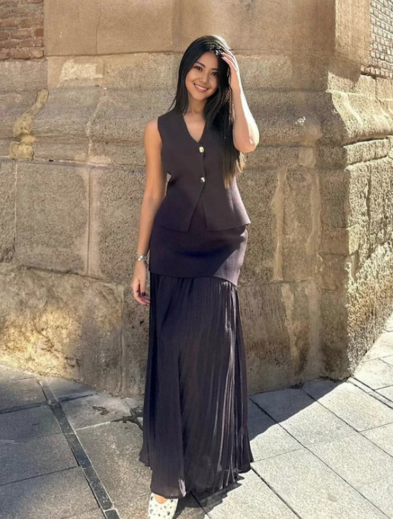 Dark maroon sleeveless vest with gold buttons and pleated midi skirt