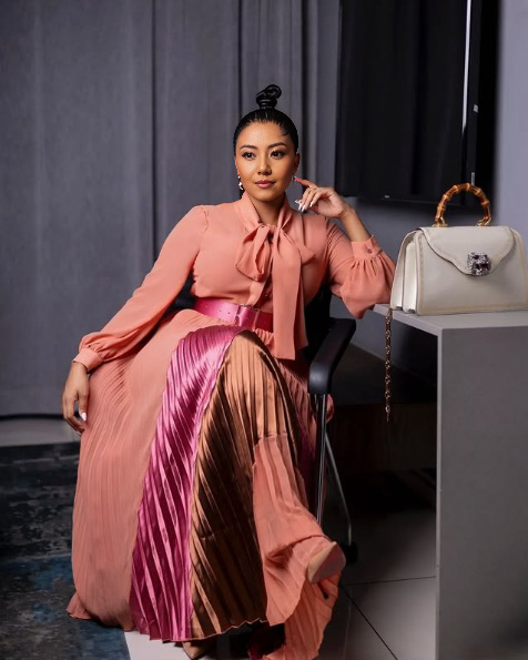 Blush pleated evening dress with geometric bow collar and long sleeves