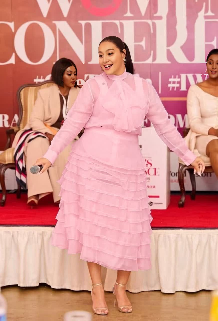 Women's pink sheer tiered midi set with ruffled skirt and long-sleeve top.