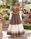 Women's two-tier printed maxi dress with a fitted brown bodice and cream skirt with striped hem