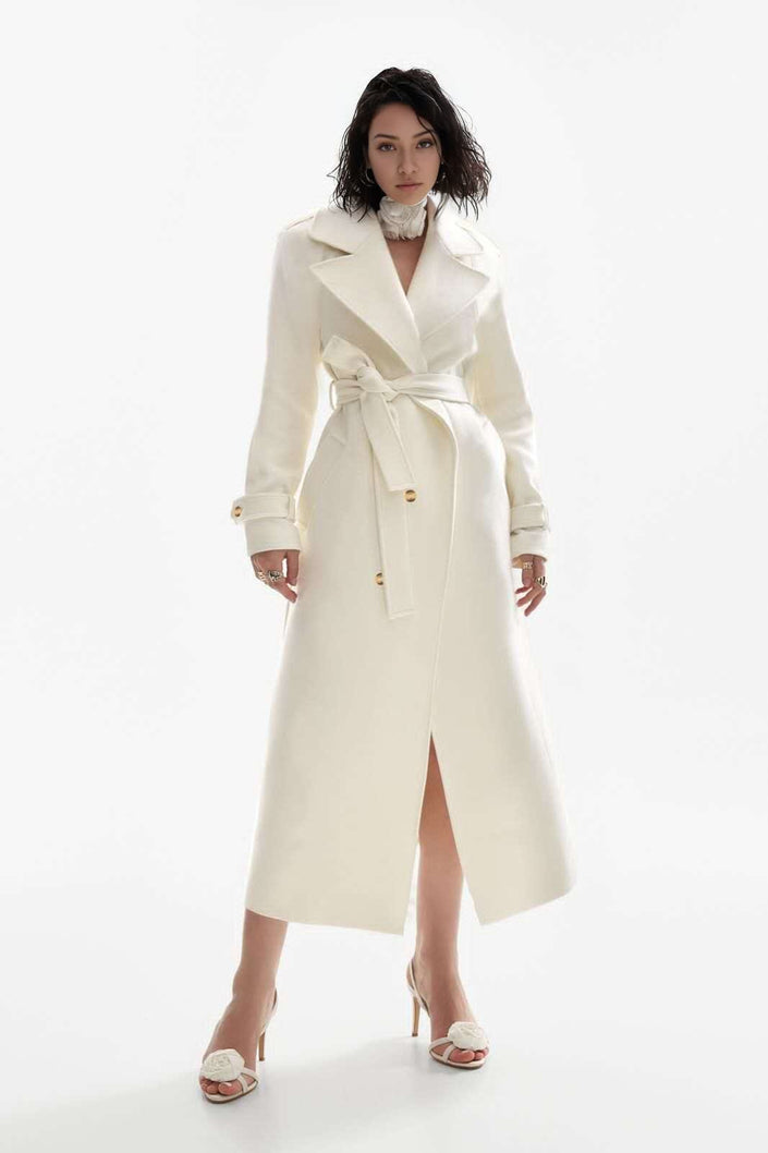 White double-breasted belted coat with wide lapels and long sleeves, midi length.
