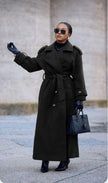 Black double-breasted belted coat with wide lapels and long sleeves, ankle length.