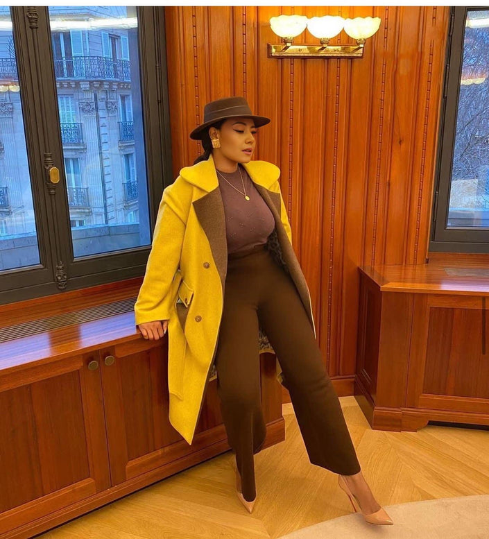 Belted yellow trench coat with notched lapels and buttoned front, long sleeves