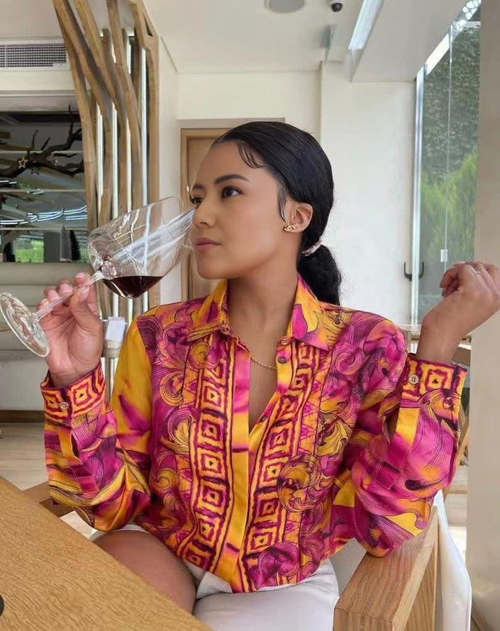 Vibrant printed long-sleeve blouse with button front and collared neckline, pink and yellow