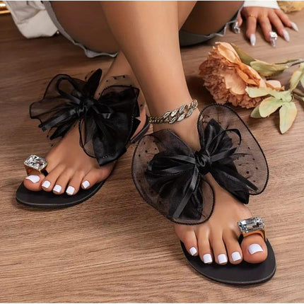 Women's black flat thong sandals with large tulle bow and crystal square strap