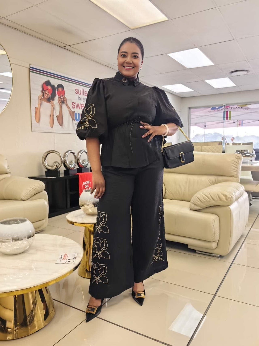 Black puff-sleeve top and wide-leg pants with floral embroidery on legs