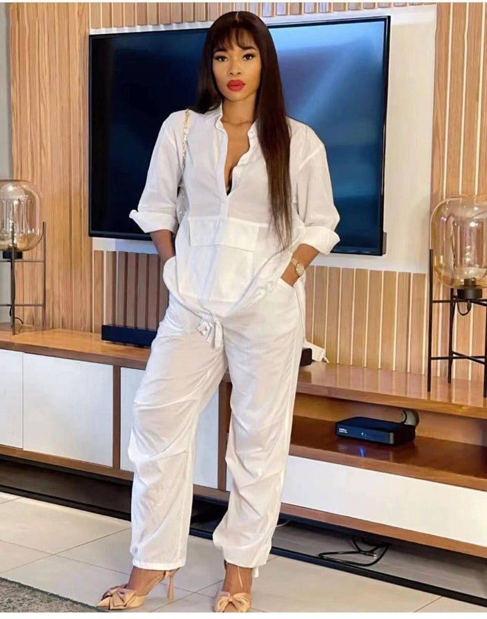 White solid color jumpsuit with long sleeves, V-neck, and adjustable waist ties