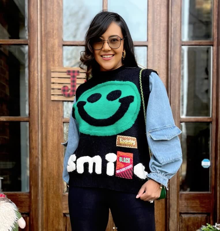 Black knit top with large turquoise smiley face front
