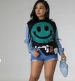 Black knit top with turquoise smiley graphic and ribbed hem