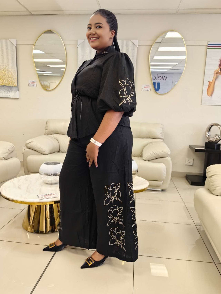 Black puff-sleeve top and wide-leg pants with floral embroidery on side seams