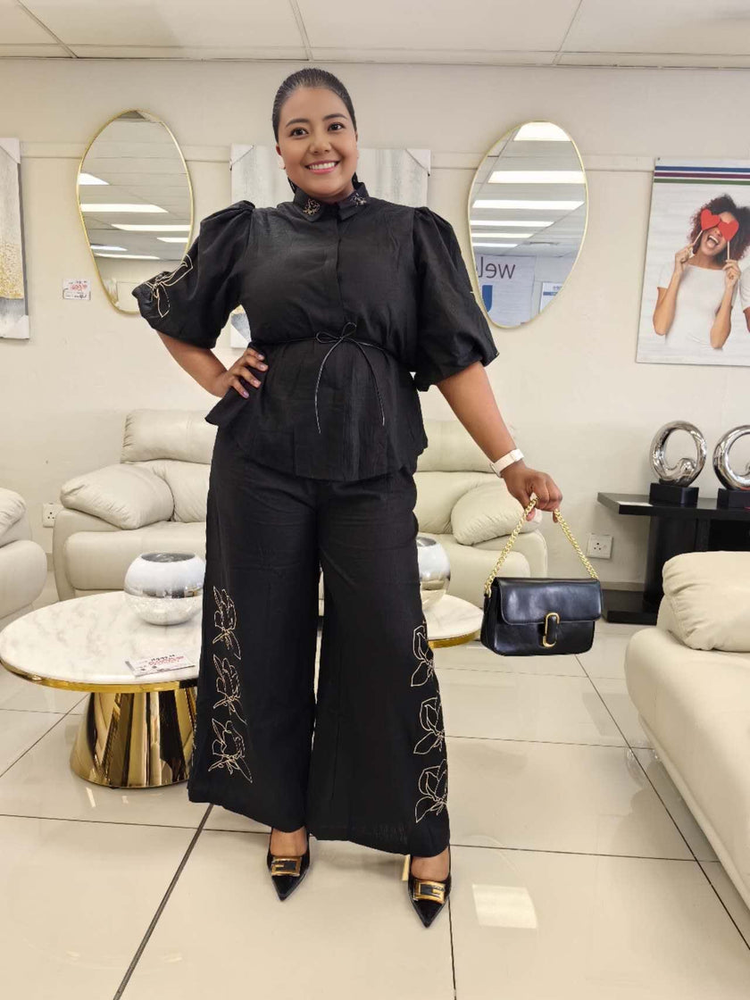 Black puff-sleeve top and wide-leg pants with floral embroidery and drawstring waist